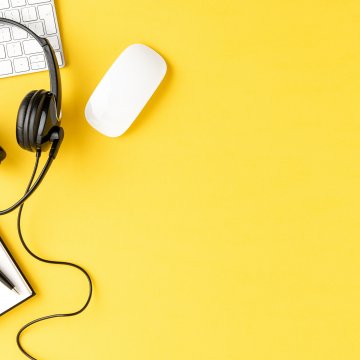 residential voip services best 2020 notebook pen headset mouse and white computer keyboard black headset yellow background